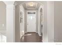 Bright entryway with hardwood floors, arched doorway, and stained glass at 8780 Foxfire St, Firestone, CO 80504