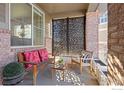 Covered porch with seating area, decorative screen, and potted plants at 8780 Foxfire St, Firestone, CO 80504