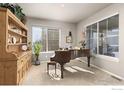 Elegant living room with piano, built-in shelving, and large windows at 8780 Foxfire St, Firestone, CO 80504