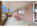 Covered front porch with red rocking chairs, offering a relaxing outdoor space at 1221 Cedar Dr, Berthoud, CO 80513