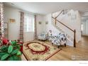 Bright living room with wood floors, comfy seating, and a staircase at 21837 E Stanford Cir, Aurora, CO 80015