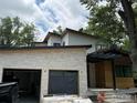 Modern home featuring a stone facade, flat roof, and an attached two-car garage at 2250 Bluebell Ave, Boulder, CO 80302
