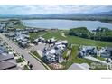Breathtaking aerial view of the community by the lake, boasting a golf course and mountain views at 2294 Stonebrae Ct, Berthoud, CO 80513