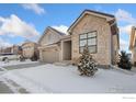 Two-story house with stone and wood exterior, two-car garage, and snowy front yard at 3351 Heron Lakes Pkwy, Berthoud, CO 80513