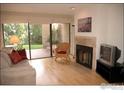 Living room with hardwood floors, fireplace, and patio access at 3805 Northbrook Dr # A, Boulder, CO 80304