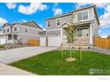 Two-story house with gray siding, two-car garage, and front porch at 4207 Sandstone Dr, Mead, CO 80504