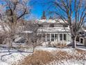 Back exterior view of home showing sun room and snow covered back yard at 4667 Ashfield Dr, Boulder, CO 80301