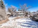 Backyard with a fire pit and a charming two-story home with a lovely enclosed sunroom at 4667 Ashfield Dr, Boulder, CO 80301