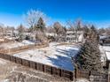 A snow covered backyard with a dark stained wood fence surrounding property at 4667 Ashfield Dr, Boulder, CO 80301