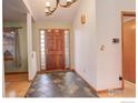 Bright and spacious entryway with wood floors and a large door at 498 Eisenhower Dr, Louisville, CO 80027