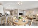 Open concept dining area with wood flooring and a view into the kitchen at 827 Ledge St, Lochbuie, CO 80603