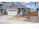 Charming one-story house with gray siding, stone accents, and a landscaped yard at 827 Ledge St, Lochbuie, CO 80603