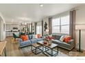 Open concept living space with gray couch, coffee table, and kitchen view at 2257 Base St, Fort Lupton, CO 80621