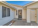Front entrance of the home with a gray door and small patio area at 246 S 22Nd Ave, Brighton, CO 80601