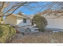 Side view of the house, showcasing a wooden retaining wall and landscaping at 246 S 22Nd Ave, Brighton, CO 80601