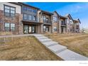 Attractive townhouses showing stone accents, balconies, individual entryways, sidewalks, and a playground at 255 High Point Dr # 204, Longmont, CO 80504