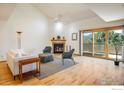 Bright living room featuring vaulted ceilings, fireplace, hardwood floors, and sliding glass door to balcony at 2938 Kalmia Ave # 6, Boulder, CO 80301