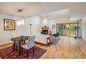 Open-concept living space with wood floors, fireplace, a dining table, and natural light from the sliding glass doors at 2938 Kalmia Ave # 6, Boulder, CO 80301