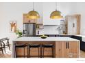 Modern kitchen with white quartz countertops, stainless steel appliances, and light wood cabinets at 4046 Niblick Dr, Longmont, CO 80503