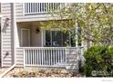 Close exterior of home featuring a balcony, green shrubbery, a front door, and manicured rocks at 4840 Twin Lakes Rd # 7, Boulder, CO 80301