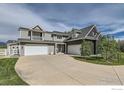 Beautiful home featuring a three-car garage, gray siding, and a well-maintained lawn at 7401 Deerfield Rd, Longmont, CO 80503