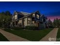 Two-story townhome exterior view at night, showing home's lighting and landscaping at 13900 Lake Song Ln # B6, Broomfield, CO 80023