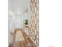 Bright entryway with wood-look flooring, decorative wall art, and a console table at 2237 Crosswind St, Fort Lupton, CO 80621