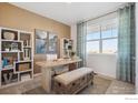 Home office with built-in shelving, window seating, and a workspace at 2237 Crosswind St, Fort Lupton, CO 80621