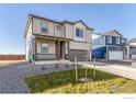 Two-story house with gray and beige siding, red door, landscaping, and a two-car garage at 2262 Base St, Fort Lupton, CO 80621
