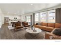 Open concept living and kitchen area with hardwood floors and modern furniture at 2262 Base St, Fort Lupton, CO 80621