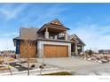 Two-story home with a balcony, stone accents, and a three-car garage at 2648 Bluewater Rd, Berthoud, CO 80513
