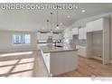 Under construction kitchen featuring an island and white cabinetry at 5753 Pintail Way, Frederick, CO 80504
