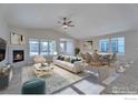Bright, open-concept living room with a modern fireplace and dining area featuring large windows at 5753 Pintail Way, Frederick, CO 80504