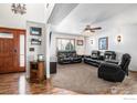 Inviting living room with hardwood floors, neutral carpet, and comfortable black leather furniture at 580 Mount Massive St, Berthoud, CO 80513