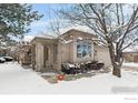 Brick ranch home with snow-covered landscaping and attached garage at 7329 Windsor Dr, Boulder, CO 80301