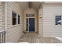 Front entrance with a dark blue door and wood deck at 7329 Windsor Dr, Boulder, CO 80301
