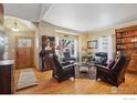 Spacious living room with hardwood floors, comfortable seating, and a wood-burning fireplace at 7909 Fairfax Ct, Niwot, CO 80503