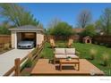 Landscaped backyard with garage, entertainment deck and green lawn at 1171 Quebec St, Denver, CO 80220