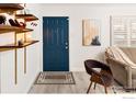 Front entry with blue door, wood chair, and shelves at 1171 Quebec St, Denver, CO 80220