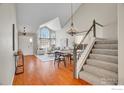 Open concept living and dining area with hardwood floors and a grand staircase at 1542 Snap Dragon Ct, Superior, CO 80027