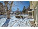 Snowy backyard with trees, white fence, and pathway at 2253 Columbine Ave, Boulder, CO 80302