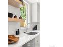 Modern kitchen with a stainless steel sink, white subway tile backsplash and white countertops at 3319 Broadway St, Boulder, CO 80304