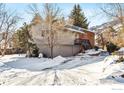 Two-story home with gray siding, brick accents, and snowy yard at 536 Linden Park Dr, Boulder, CO 80304