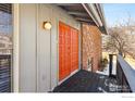 Bright orange double doors leading to a wooden deck at 536 Linden Park Dr, Boulder, CO 80304