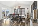 Bright dining room with hardwood floors, a large table and chairs, and plantation shutters at 6539 Empire Ave, Frederick, CO 80516