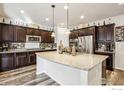 Spacious kitchen featuring granite countertops, stainless steel appliances, and dark wood cabinets at 6539 Empire Ave, Frederick, CO 80516