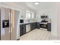 Updated kitchen featuring stainless steel appliances and white cabinets at 12802 E Nevada Cir, Aurora, CO 80012