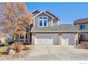 Two-story house with a three-car garage and landscaping at 1486 Clover Creek Dr, Longmont, CO 80503