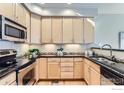 L-shaped kitchen with light wood cabinets, granite countertops, and stainless steel appliances at 4137 Clifton Ct # C, Boulder, CO 80301