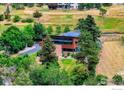 Aerial view of a modern home surrounded by greenery and trees on a spacious lot at 512 Ponderosa Dr, Boulder, CO 80303